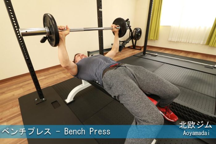 ジムでベンチプレスをする様子