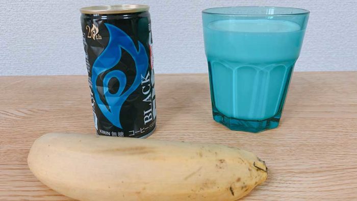 ブラックコーヒー缶とコップに入った牛乳とバナナ