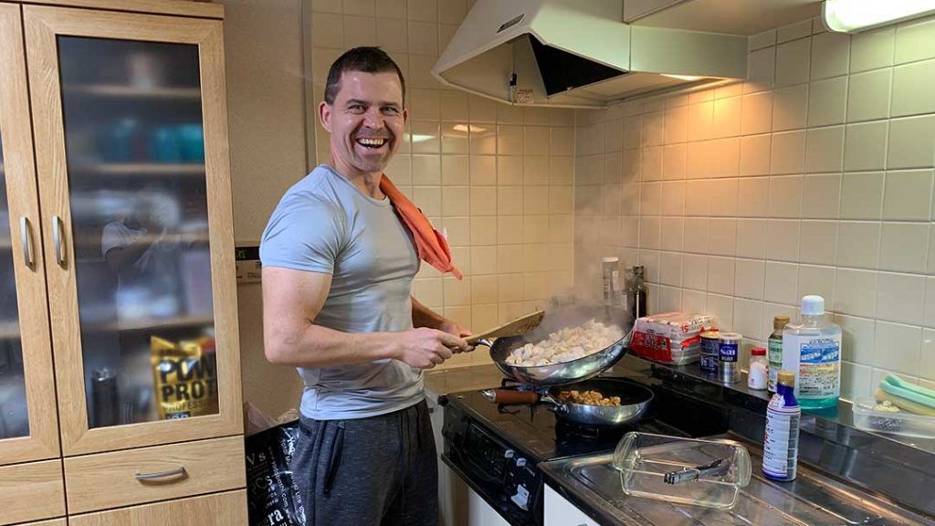 男性(Dr.heiki)がキッチンで料理をしている写真