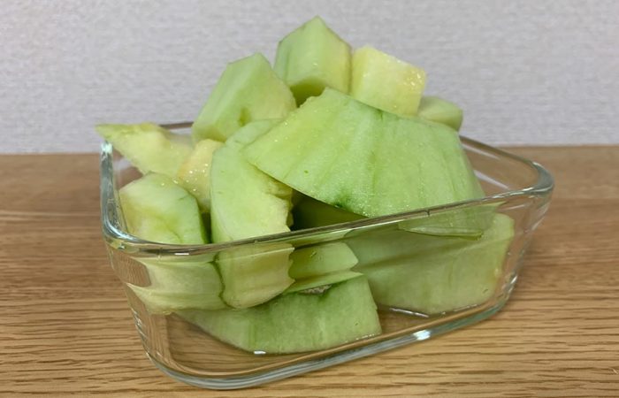 透明のお皿に入ったカットされたメロンの写真