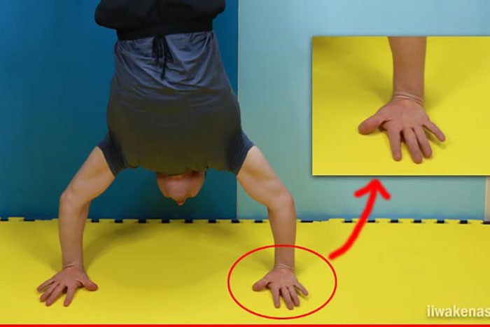 マットの上で手の甲を下にし、逆立ち男性（ヘイキさん）の写真