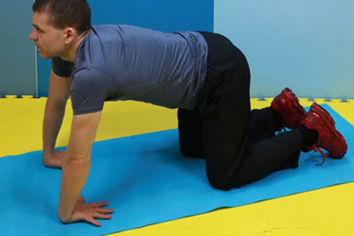 マットの上で手の甲を床につけ、リバースリストする男性(ヘイキさん)